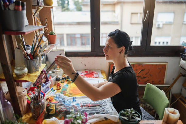 istock Female painter choosing a paintbrush while painting 1267386641