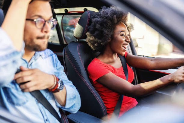 istock Young attractive multicultural hipster couple sitting in car and driving. 1267390358