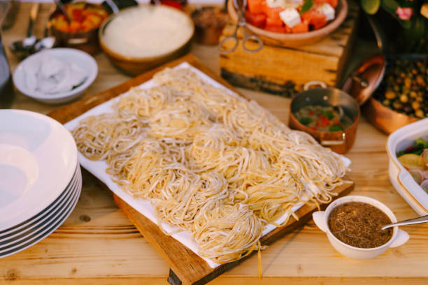 spaghetti sur une planche de bois pour la coupe avec des repas cuits et des assiettes propres. - macaroni cheese food staple casserole photos et images de collection