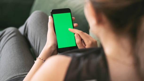 istock Young woman using mobile phone with chroma key screen 1267391325