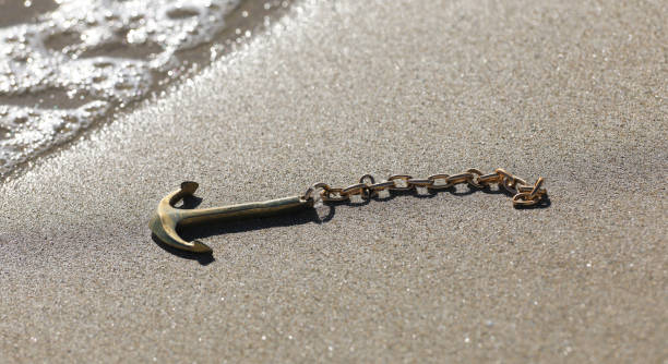 istock sea anchor on the sea sand 1267391675