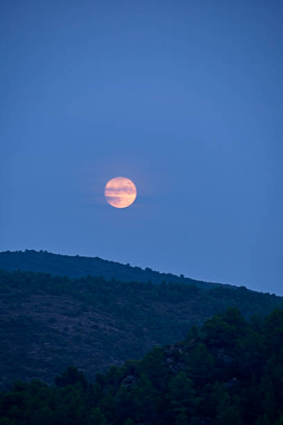 istock The moon rising between the mountains 1267392618