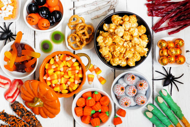 istock Halloween candy buffet table scene over a white wood background 1267394795