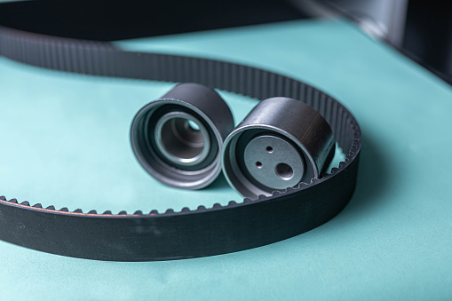 New set of timing belt and idler pulleys on a blue background.