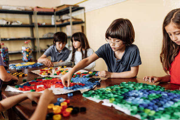 istock Elementary school pupils creating art product from recycled plastic 1267395821