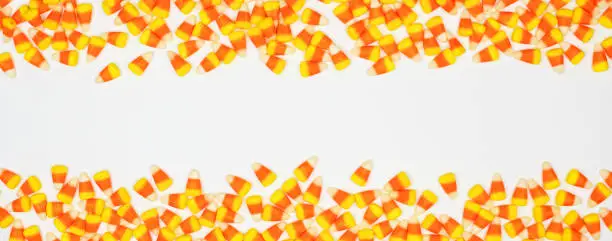 Halloween candy corn double border banner. Top view on a white background with copy space.