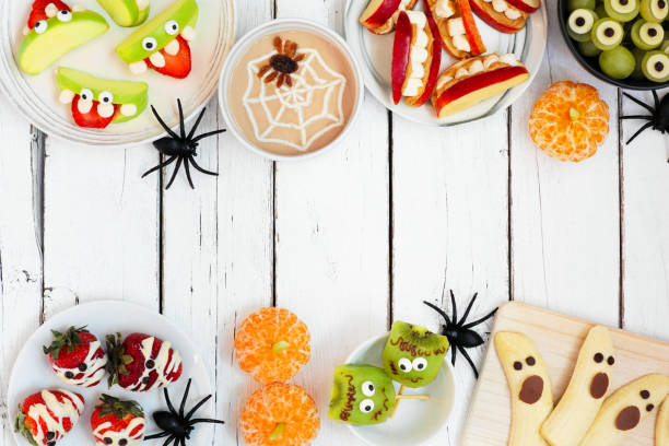 istock Healthy Halloween fruit snack double border over a white wood background 1267399893