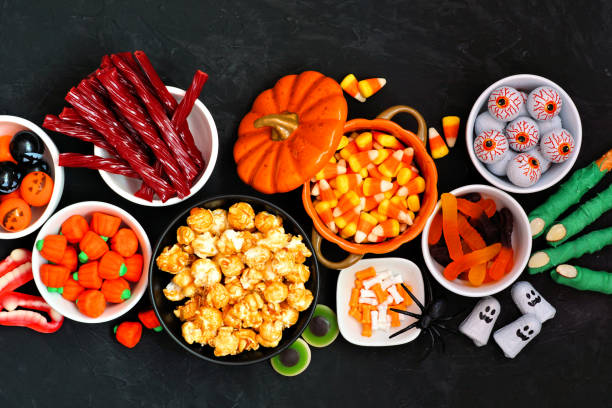 istock Halloween candy buffet table scene over a black stone background 1267401260