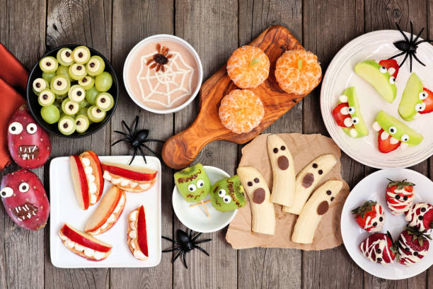 istock Healthy Halloween fruit snacks. Top view table scene over a wood background. 1267401611
