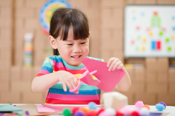 young girl making craft for home schooling
