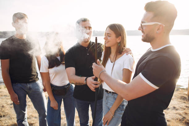 istock Young people eating pizza smoking hookah outside 1267407350