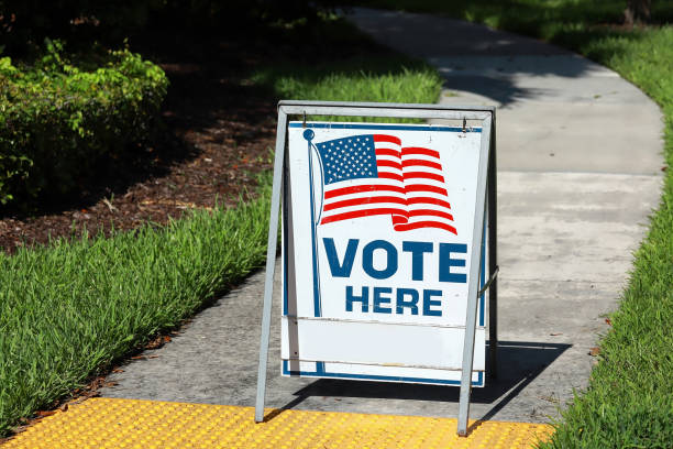 Voting sign on the walkway VOTE HERE SIGN placed on the walkway to a neighborhood polling place, as seen on election day in Fort Lauderdale, Florida. polling place photos stock pictures, royalty-free photos & images