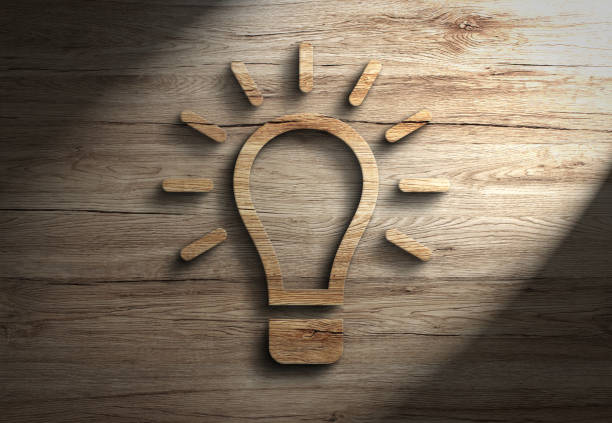 istock Wooden 3d lightbulb lamp innovation creativity energy symbol with spotlight 1267411535