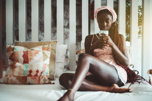 afrikanische mädchen trinken tee im bett - hairstyle braids naked women stock-fotos und bilder