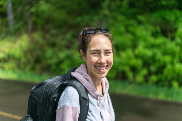 istock Young ethnic woman walking along the road with a backpack 1267417004
