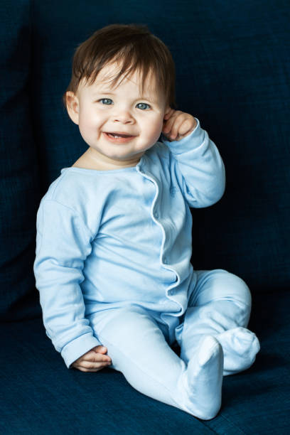 istock Cute little boy is playing on blue sofa 1267417375