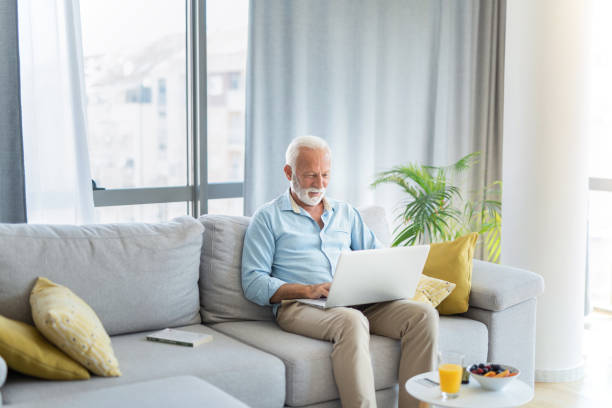 istock Happy senior man using laptop in the living room. 1267420228
