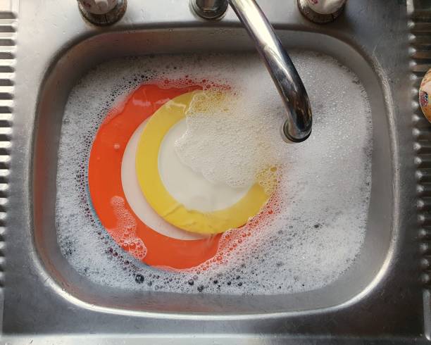 istock Colourful crockery in soapy water. 1267420232