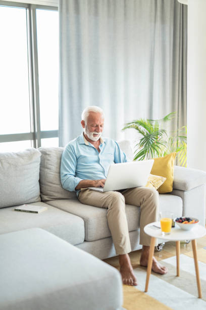 istock Happy senior man using laptop in the living room. 1267420236