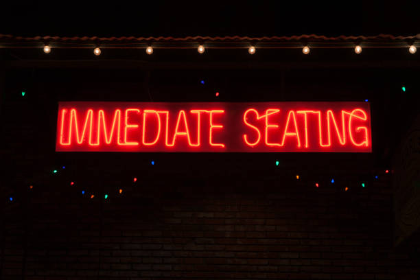 istock Bright red neon sign offering immediate seating 1267422513