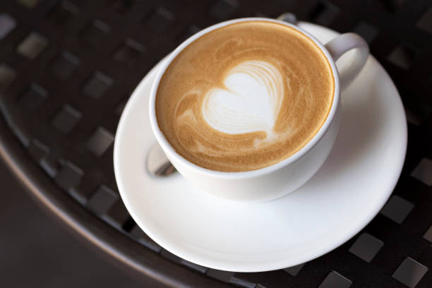 istock Cup of coffee with latte art on black table 1267424962