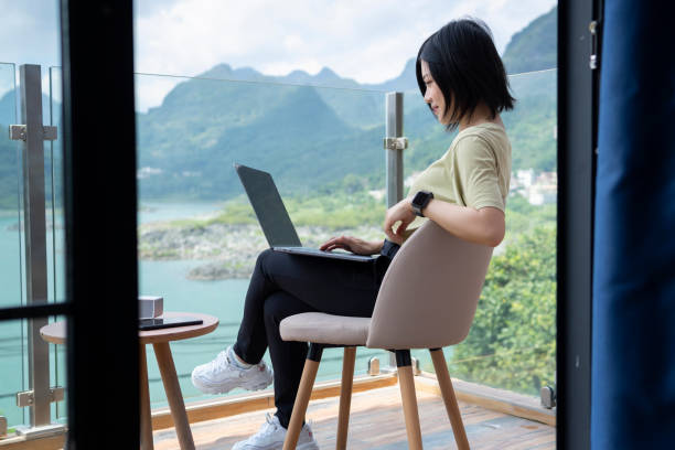 istock An asian young female freelancer using a laptop to work outdoors on the journey 1267427365