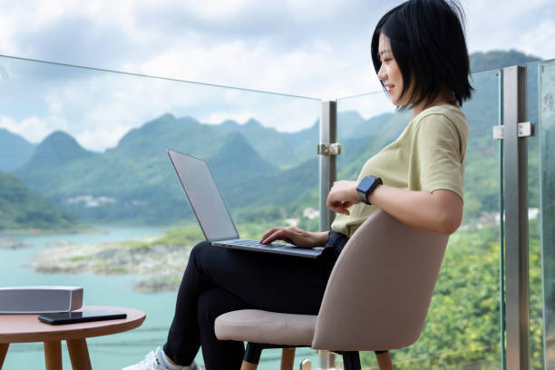 una joven asiática freelancer usando un portátil para trabajar al aire libre en el viaje - lake asia young women beautiful people fotografías e imágenes de stock