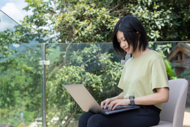 istock An asian young female freelancer using a laptop to work outdoors on the journey 1267427381