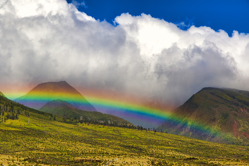 Beautiful rainbow across a montain on Maui.