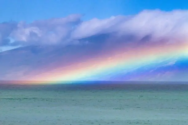 Dramatic rainbow over ocean with Molokai in the distance.