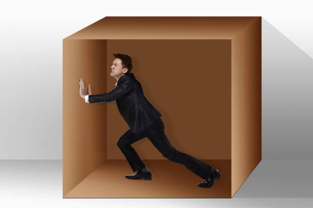 istock Businessman trapped inside a box,pushing against it 1267435920