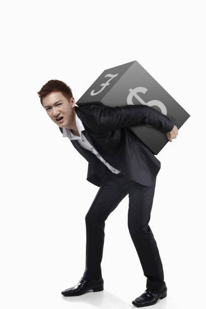 istock Businessman lifting a cube on his back with currency signs 1267437689