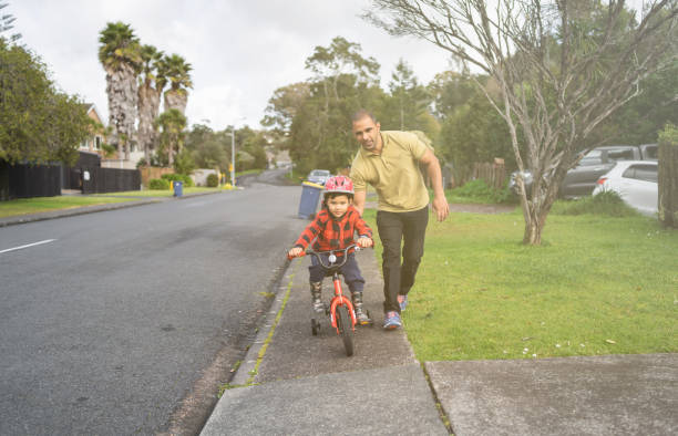istock Father helping son to learn bike. 1267438586