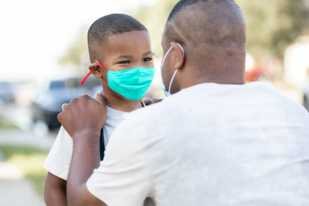 istock Father and elementary age son wear masks and say goodbye as father drops son off for first day back to school during time of coronavirus 1267440180