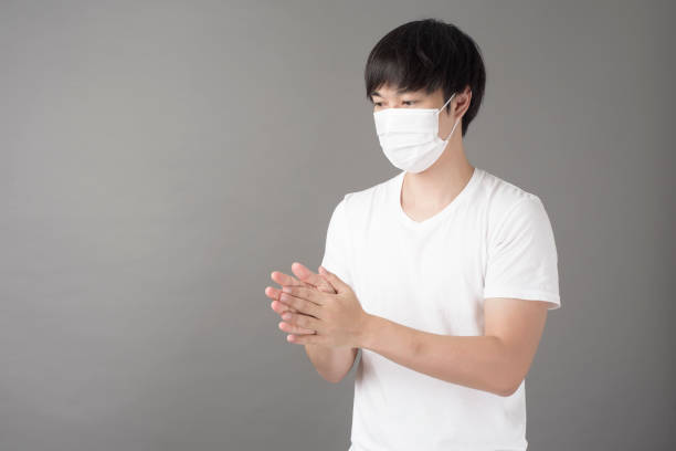 istock A handsome man with surgical mask is using alcohol hand sanitizer 1267447968