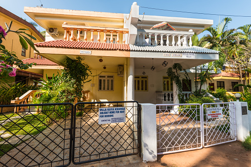 Candolim, North Goa, India - November 23, 2019: Street view of Candolim at sunny day with typical holiday home or guest house in Candolim, North Goa, India.