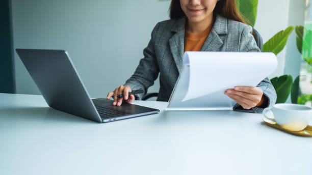 istock Businesswoman working on financial paperwork and laptop computer 1267453969