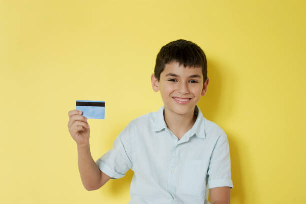 istock Smiling little boy holding a credit card 1267458684