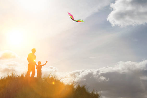 förälder med barn som leker med drake på toppen av backen - flying kite bildbanksfoton och bilder