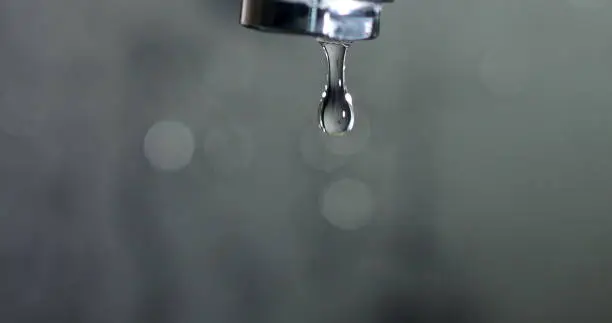 Drop of water drips from the tap