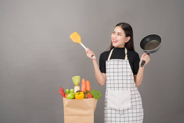 Happy woman is preparing healthy food to cooking Happy woman is preparing healthy food to cooking basket healthy eating vegetarian food studio shot stock pictures, royalty-free photos & images