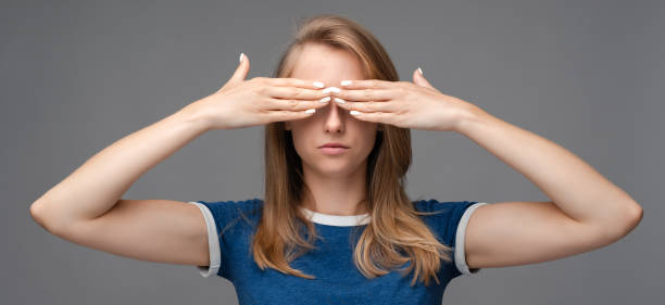 giovane femmina con i capelli biondi, si copre le mani. concetto di emozioni umane - serious women human face teenager foto e immagini stock