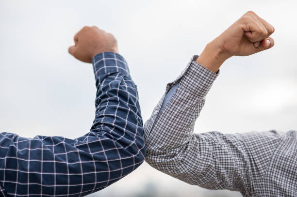 istock Two businessmen Shaking elbows keeping social distancing. 1267469247