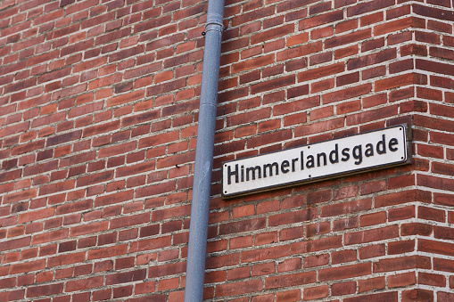 Street sign on a brown concrete building in Denmark