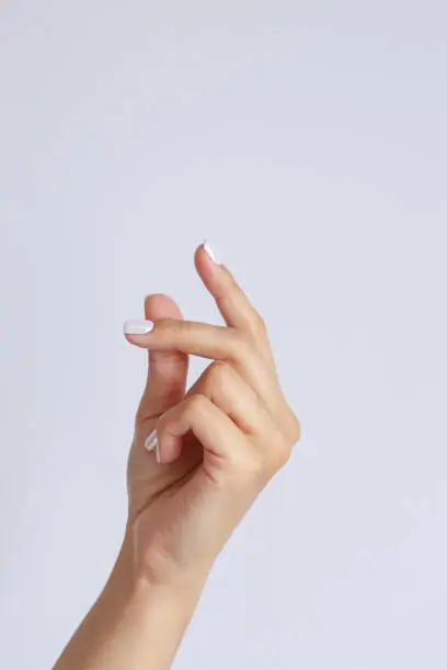 Gesture and sign, female hand on a white background. hand click or snapping fingers