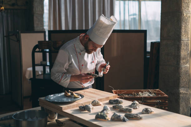 istock Opening the hollow and flat oysters. Chef opens oysters in the restaurant. 1267471588