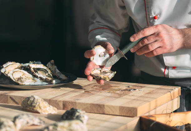istock Opening the hollow and flat oysters. Chef opens oysters in the restaurant. 1267471749