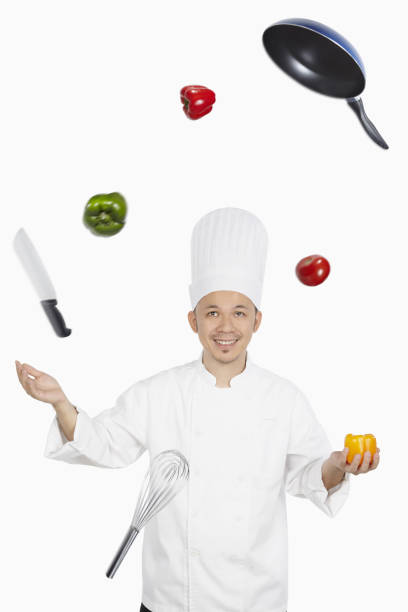 istock Asian chef juggling vegetables and kitchen utensil 1267471983