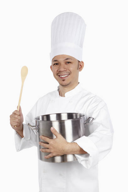 istock Asian chef holding a stew pot and a wooden spoon 1267472007
