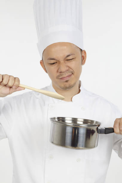Asian chef cooking with saucepan,looking disappointed